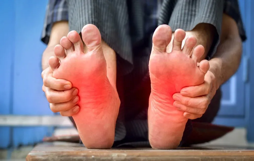 Person's bare feet with red highlighted pain points indicating neuropathy symptoms